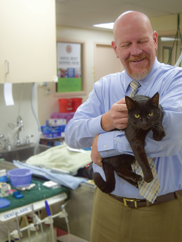 Sacramento SPCA CEO, Kenn Altine, enjoys a comforting moment with cat Tomasina prior to her surgery in the shelter's spay & neuter clinic.