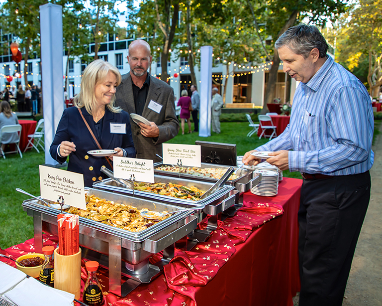 Reeve-Knight Construction's Kerry Bal and Todd Swanson, and Heather Swanson of Ameriprise Financial, enjoy the feast prepared by Fat Family Restaurants