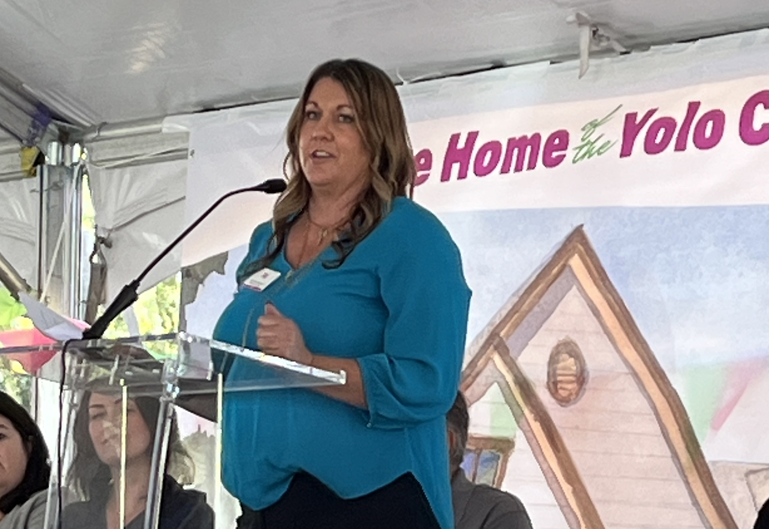 Woman in blue blouse standing at podium